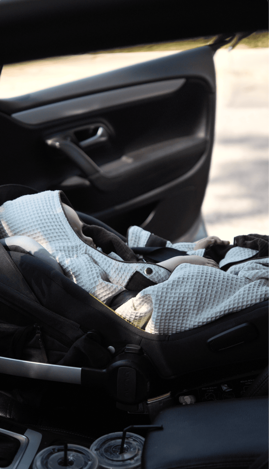 A sleeping baby in a car seat wearing the KESLOVE carrier before a seamless transfer.