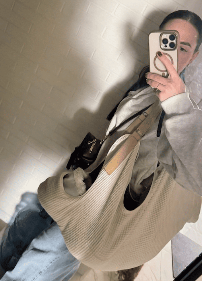 Mom taking a mirror selfie while holding her baby in the ergonomic KESLOVE newborn carrier.
