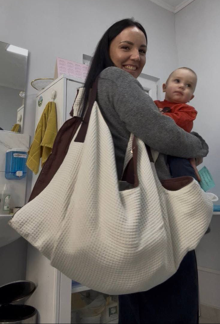 Front view of a mother carrying her infant in a KESLOVE ergonomic sling for bonding.