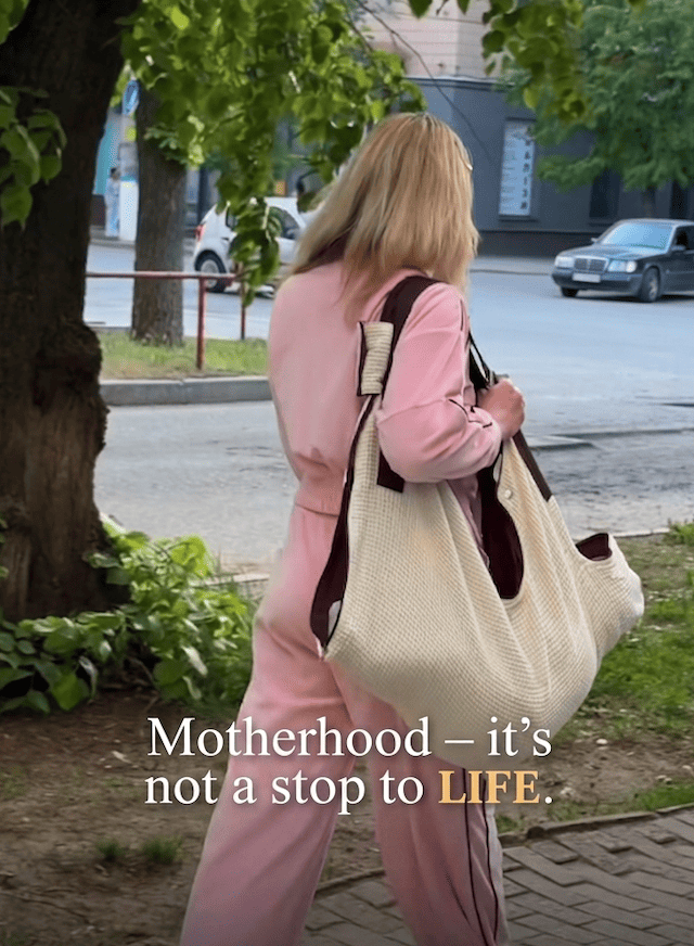 Side view of a mother using KESLOVE hands-free carrier for silent baby transfer from a car seat.
