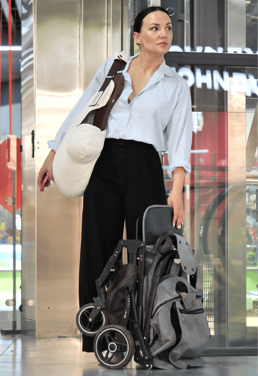 Stylish mom carrying her baby comfortably in the KESLOVE ergonomic carrier while on the go.