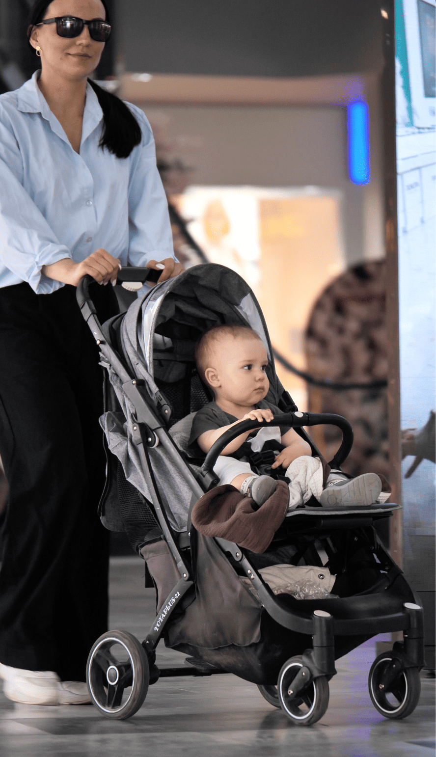 Mother enjoying hands-free comfort using the KESLOVE carrier while out with a stroller.
